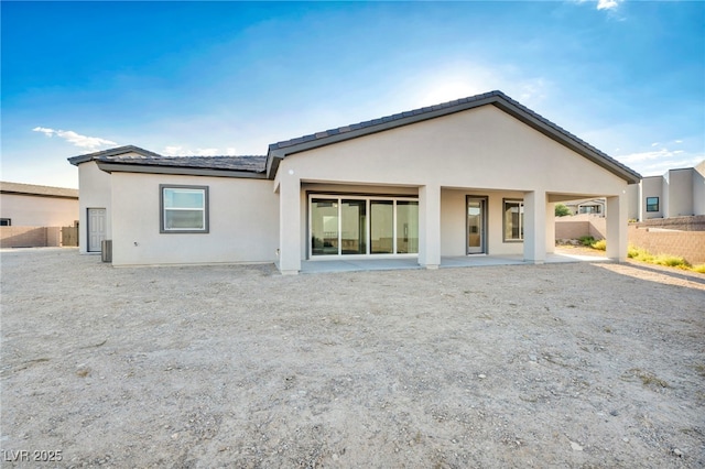 rear view of house featuring stucco siding