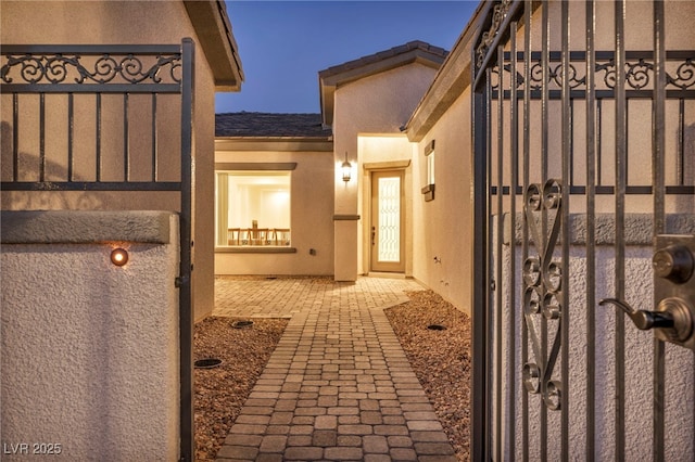 exterior space featuring a gate and stucco siding