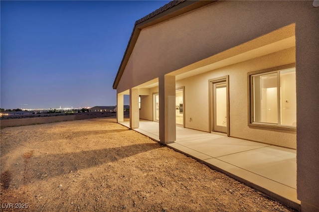 view of side of property with a patio area and stucco siding