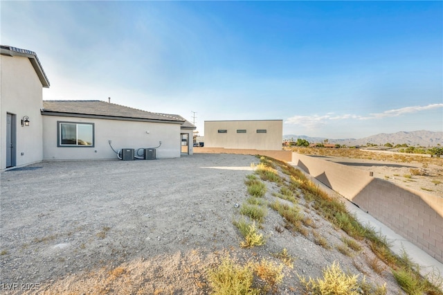 view of home's exterior featuring a mountain view, cooling unit, and stucco siding