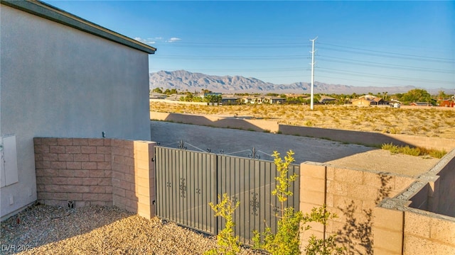 view of yard featuring a gate, a mountain view, and fence