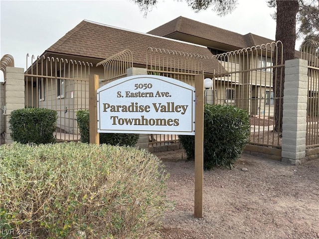 community / neighborhood sign featuring fence