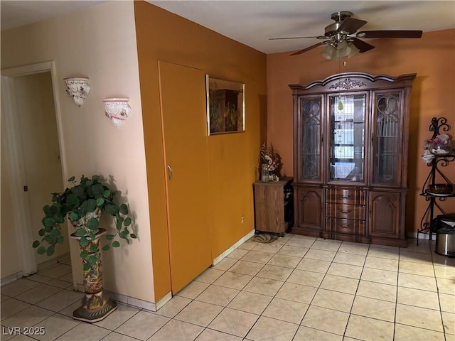 foyer with light tile patterned floors, ceiling fan, and baseboards