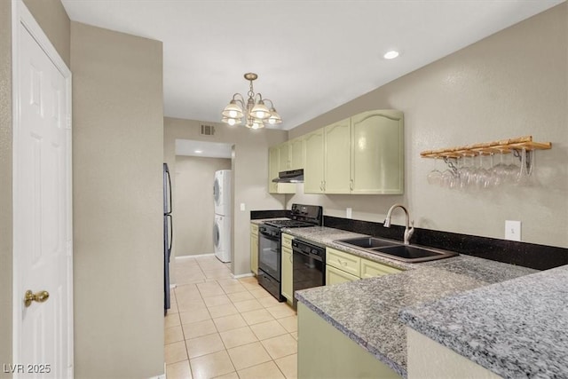 kitchen with light tile patterned floors, under cabinet range hood, stacked washer and dryer, a sink, and black appliances