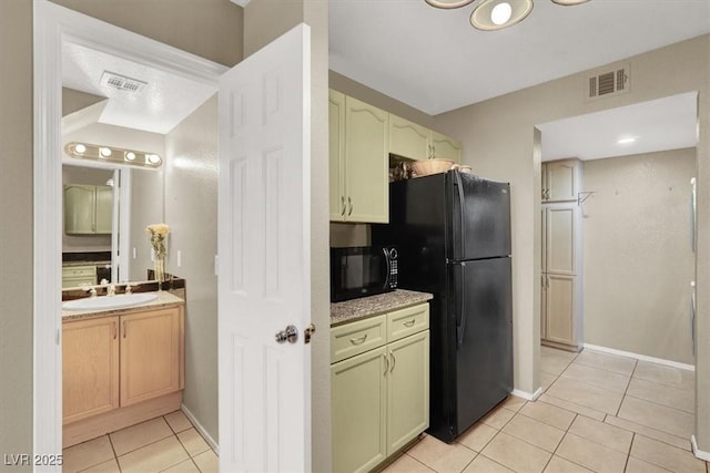 kitchen featuring black appliances, visible vents, a sink, and light tile patterned flooring