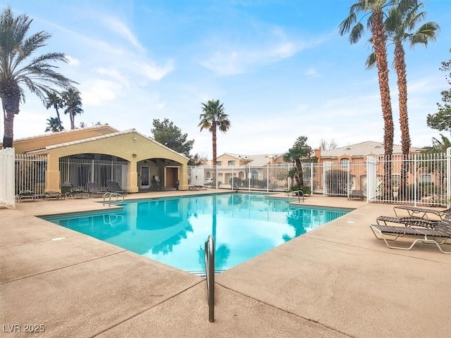 community pool with a patio and fence