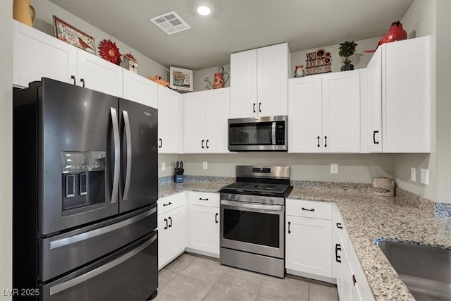 kitchen featuring visible vents, white cabinets, appliances with stainless steel finishes, light stone counters, and light tile patterned flooring