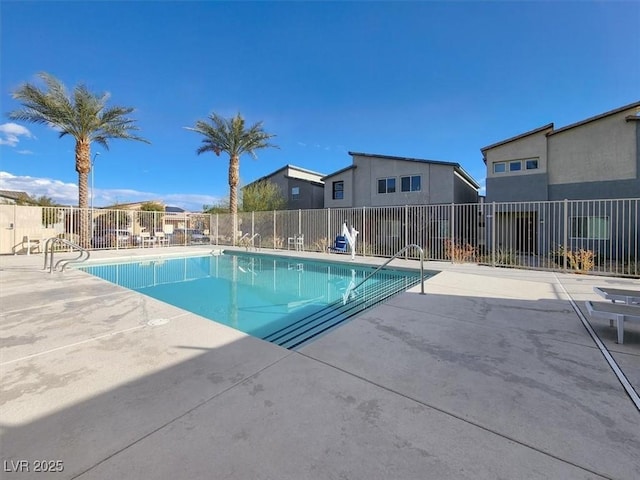 pool with a patio area and fence