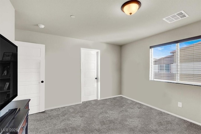 unfurnished bedroom featuring carpet floors, baseboards, and visible vents