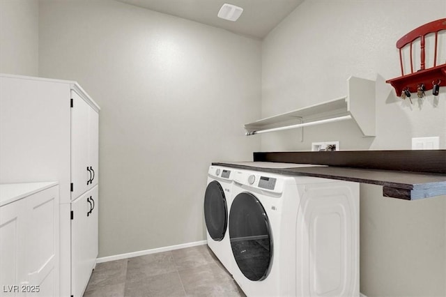 laundry area featuring light tile patterned flooring, washing machine and dryer, baseboards, cabinet space, and attic access