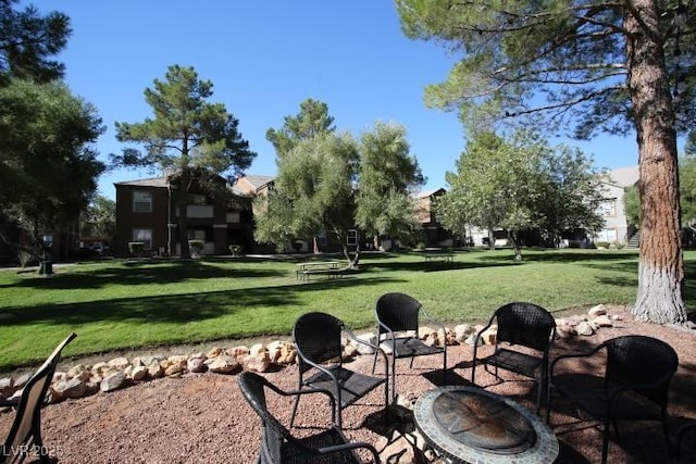 surrounding community with a patio area, a fire pit, and a lawn