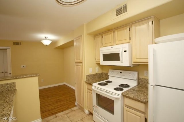 kitchen featuring light stone countertops, white appliances, visible vents, and light tile patterned flooring