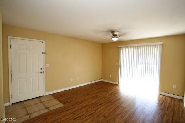 spare room with a ceiling fan, baseboards, and wood finished floors