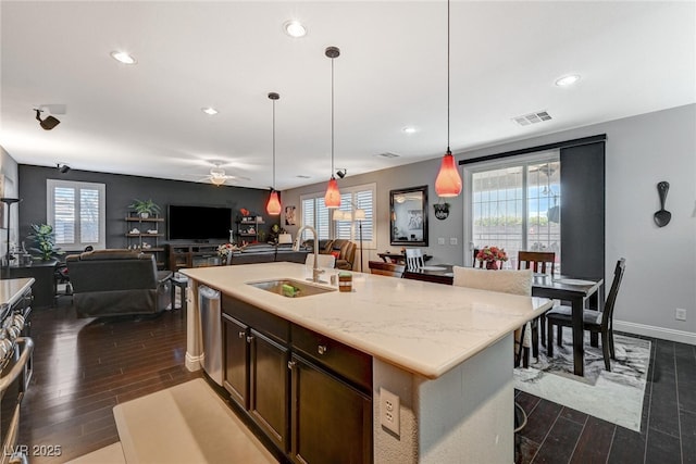 kitchen with dishwasher, a sink, dark wood finished floors, and a healthy amount of sunlight