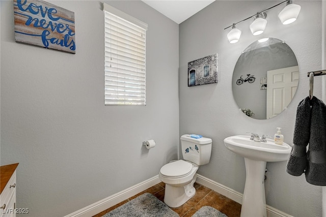 half bathroom featuring toilet, tile patterned flooring, and baseboards