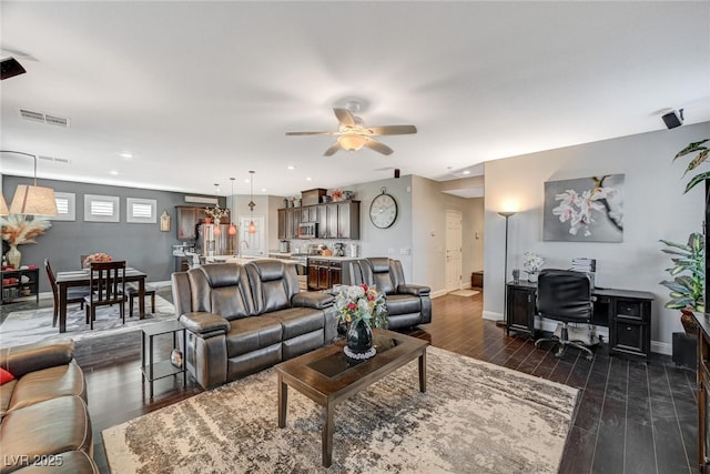 living area featuring dark wood-style floors, ceiling fan, visible vents, and baseboards