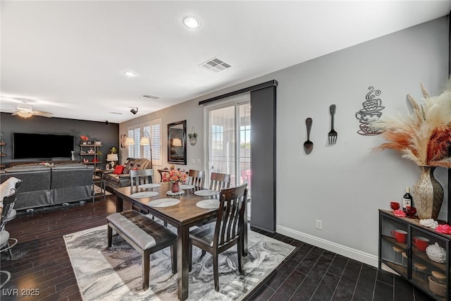 dining room with dark wood-style floors, visible vents, and baseboards