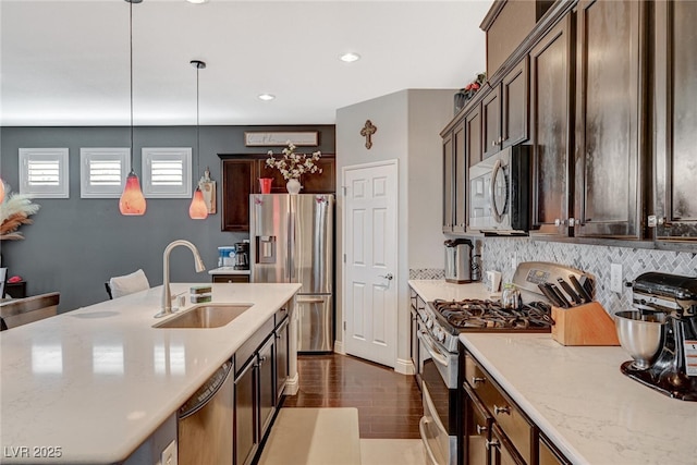 kitchen with stainless steel appliances, tasteful backsplash, a sink, and pendant lighting