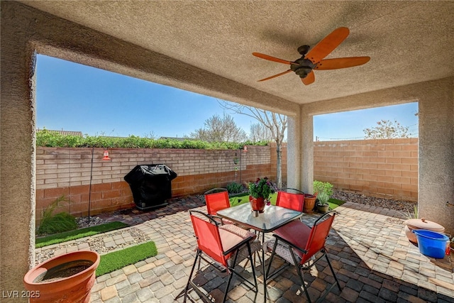 view of patio / terrace with a ceiling fan, outdoor dining area, a fenced backyard, and area for grilling