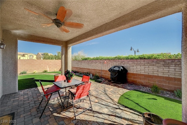 view of patio / terrace featuring outdoor dining space, grilling area, a fenced backyard, and a ceiling fan