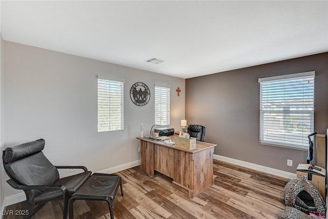 office featuring light wood-style flooring, visible vents, and baseboards