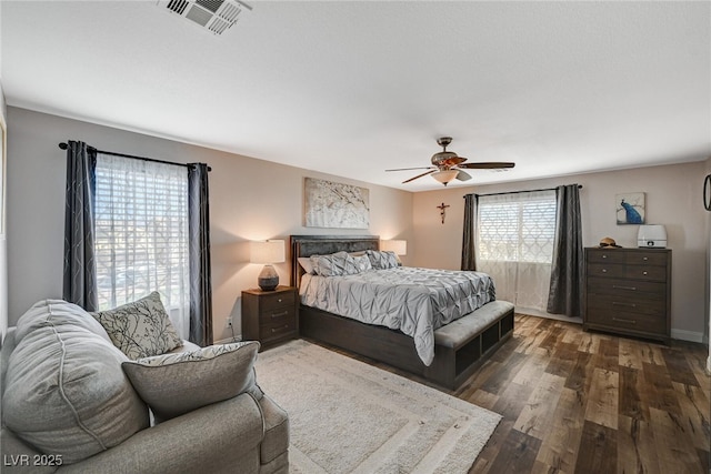 bedroom featuring dark wood-style floors, baseboards, visible vents, and a ceiling fan