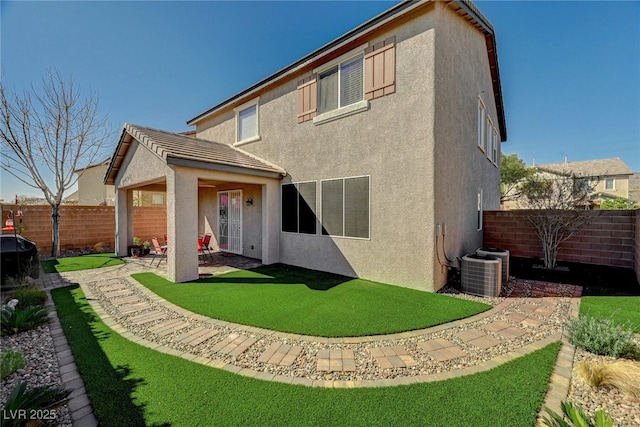 rear view of house with cooling unit, a patio area, a fenced backyard, and stucco siding