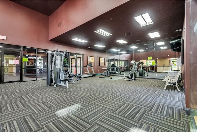 gym featuring carpet floors, a high ceiling, and visible vents