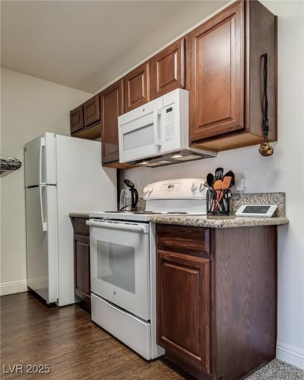 kitchen with dark wood-style floors, white appliances, and baseboards