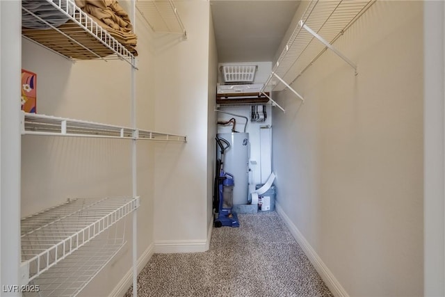 spacious closet with carpet floors and water heater