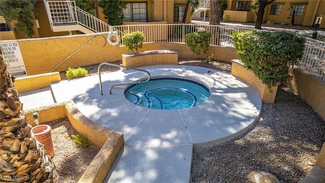 view of swimming pool featuring a hot tub and fence