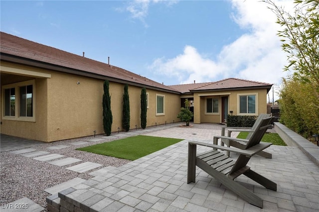 rear view of property featuring a patio area and stucco siding