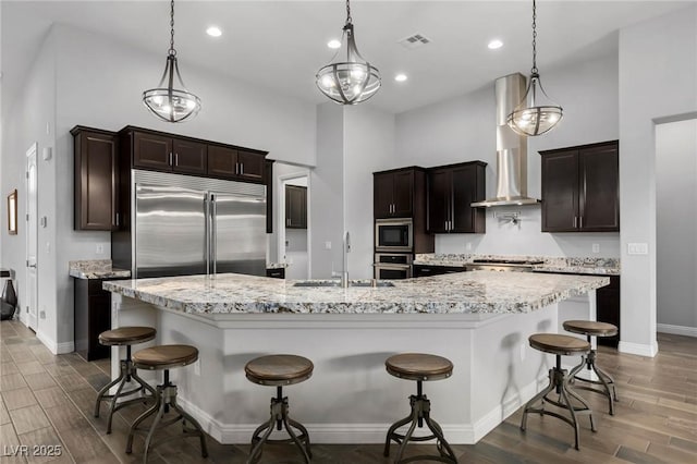 kitchen featuring built in appliances, dark wood-type flooring, a sink, and visible vents