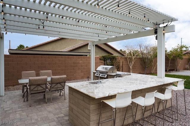 view of patio with area for grilling, outdoor dining space, grilling area, and a fenced backyard