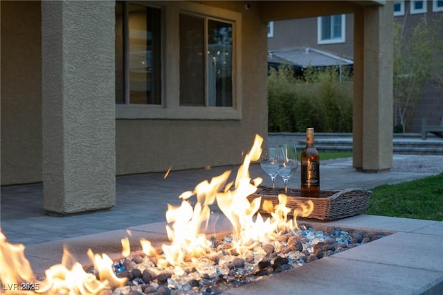 exterior details with an outdoor fire pit and stucco siding