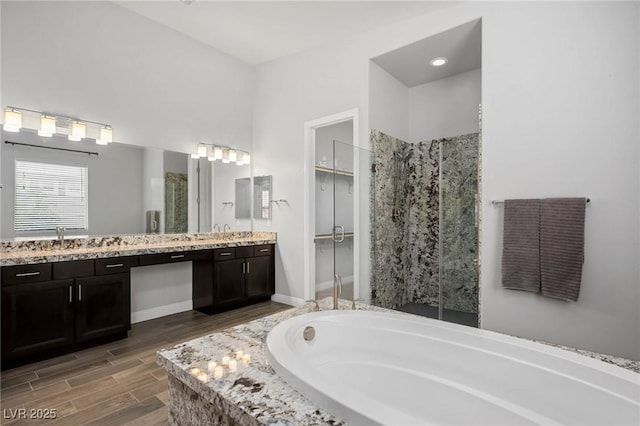 full bath with a garden tub, vanity, a shower stall, and wood finished floors