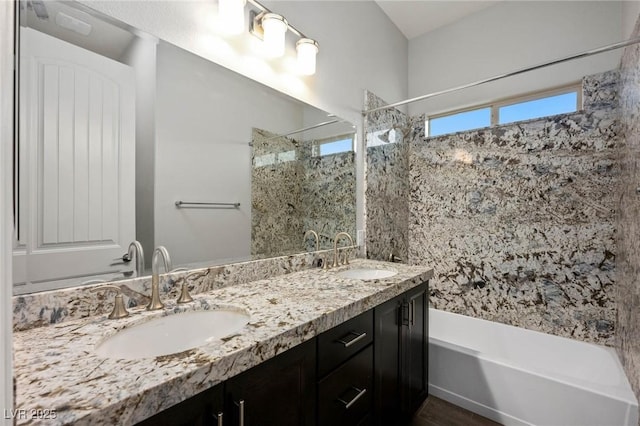 full bath featuring double vanity, a sink, and bathing tub / shower combination