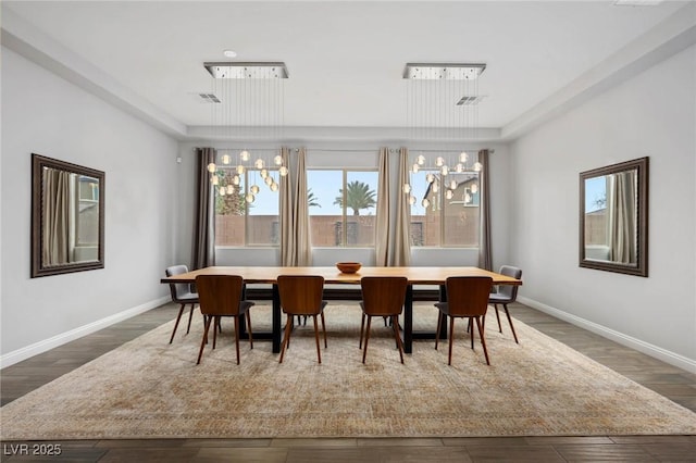 dining room with wood finished floors, visible vents, and baseboards