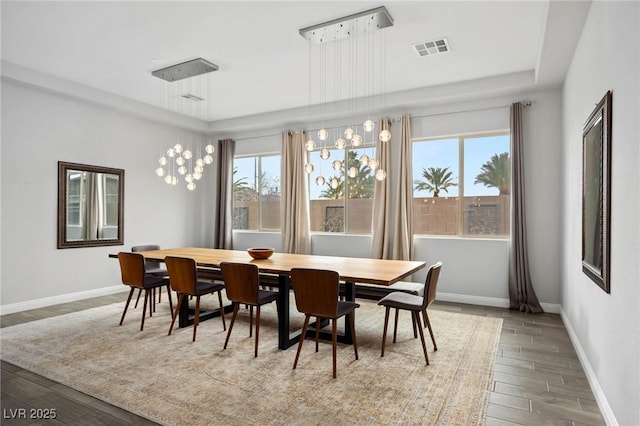 dining space featuring baseboards, visible vents, and wood finished floors