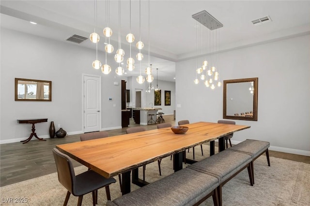 dining room with baseboards, visible vents, and wood finished floors