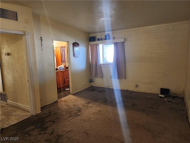 unfurnished dining area with visible vents and concrete block wall