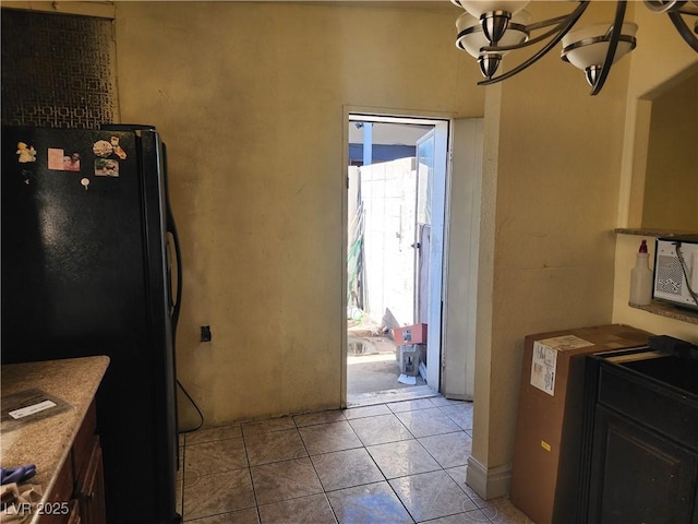 kitchen with light tile patterned flooring and freestanding refrigerator