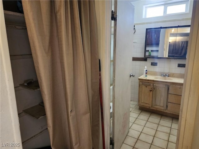 bathroom featuring vanity, tile patterned flooring, and tile walls