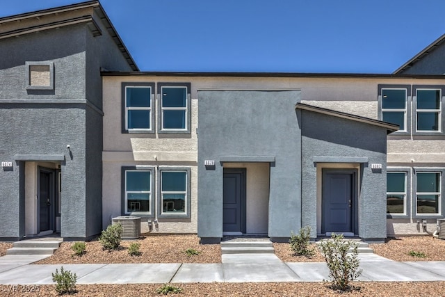 view of property featuring cooling unit and stucco siding