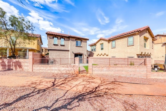 view of front of property with a tile roof, a fenced front yard, a gate, and stucco siding