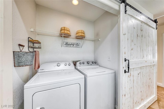 washroom with separate washer and dryer and a barn door