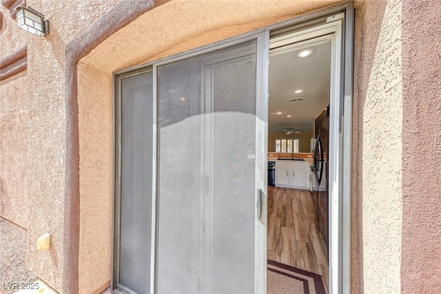 entrance to property featuring stucco siding