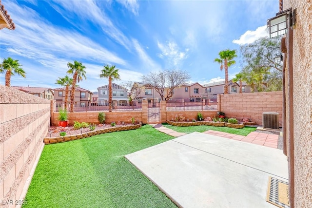 view of yard with a residential view, a fenced backyard, a patio, and central AC unit