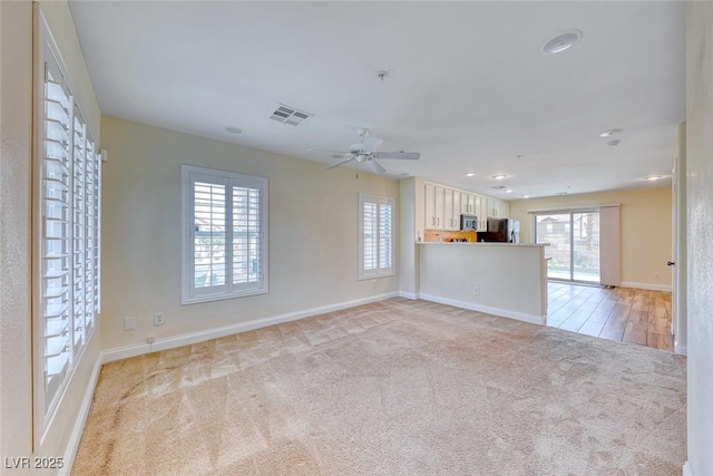 spare room with recessed lighting, light colored carpet, a ceiling fan, baseboards, and visible vents