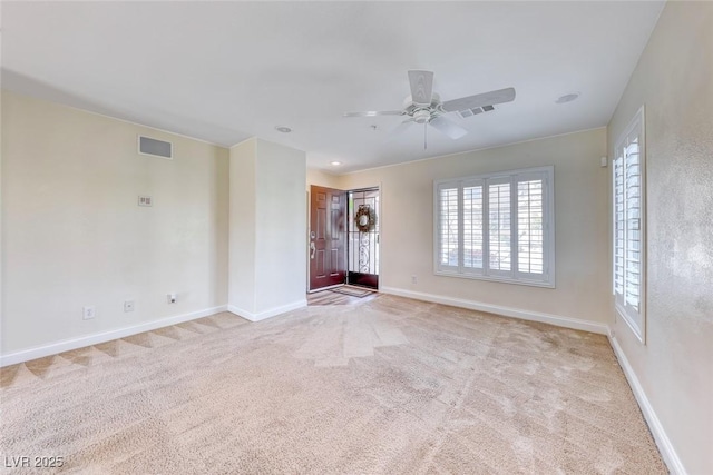 unfurnished room featuring baseboards, visible vents, and light colored carpet